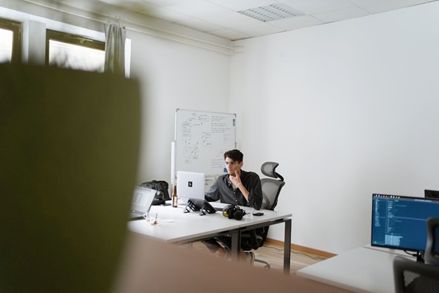 A man at an office desk, engaged in tasks about online faxing and its cost-saving advantages.