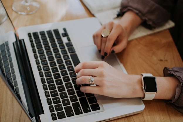 A woman's hands engaged with a laptop keyboard, representing the integration of cloud faxing for enhanced business efficiency.
